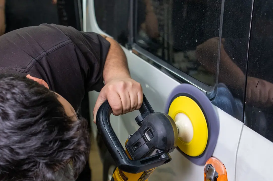 A polisher working paint in a workshop