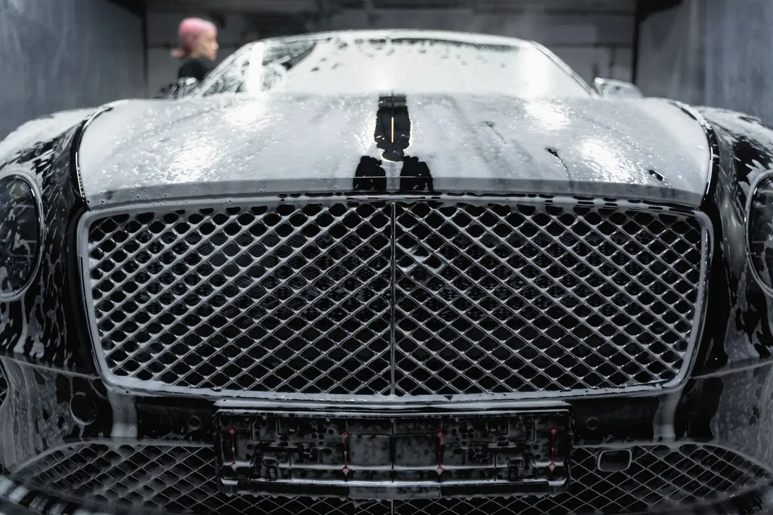 Thick soap foam covering a black car