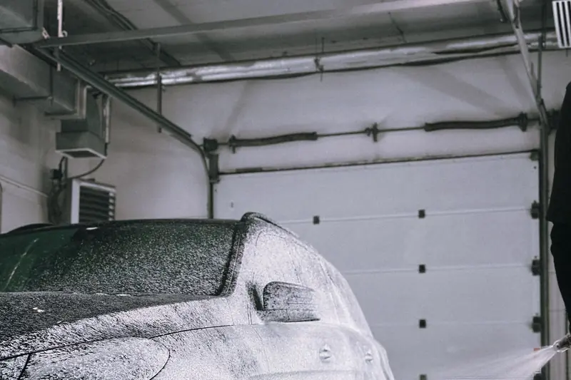 Snow foam covering a car in a garage